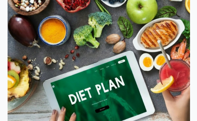 Healthy foods and tablet displaying diet plan concept