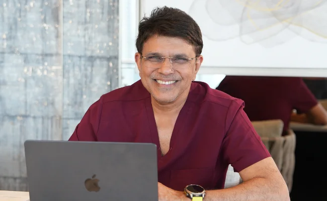 Dr. Muffazal Lakdawala on a laptop in his clinic office